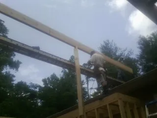 Carpenter setting a ridge beam over a new addition frame — Ice Dam Removal by Roofing Brothers in Ripley